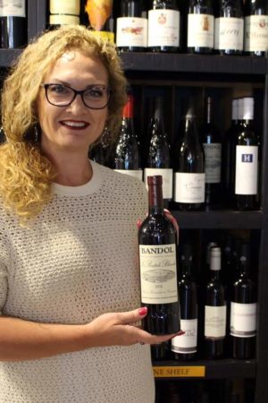 Amy presenting a bottle of wine from the Blue Goat to the viewer.